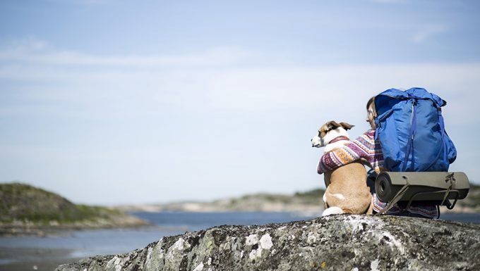 hiker with dog on rock