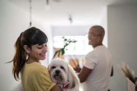 happy woman and partner bringing new dog home