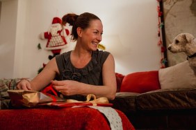 Mature woman wrapping Christmas presents at home.