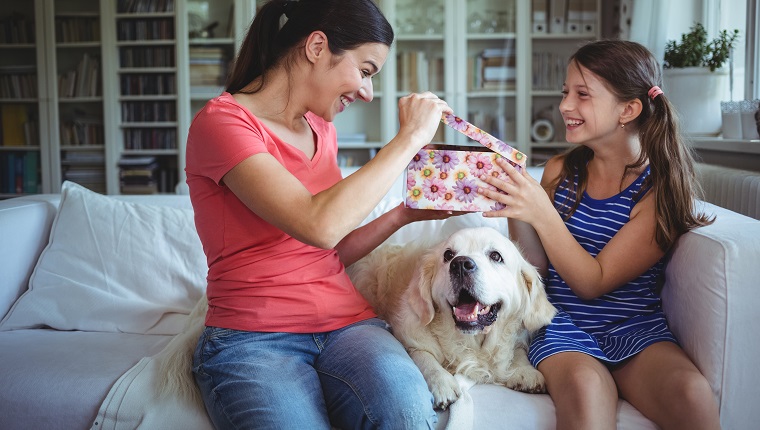 Happy mother checking the surprise gift given by her daughter at home