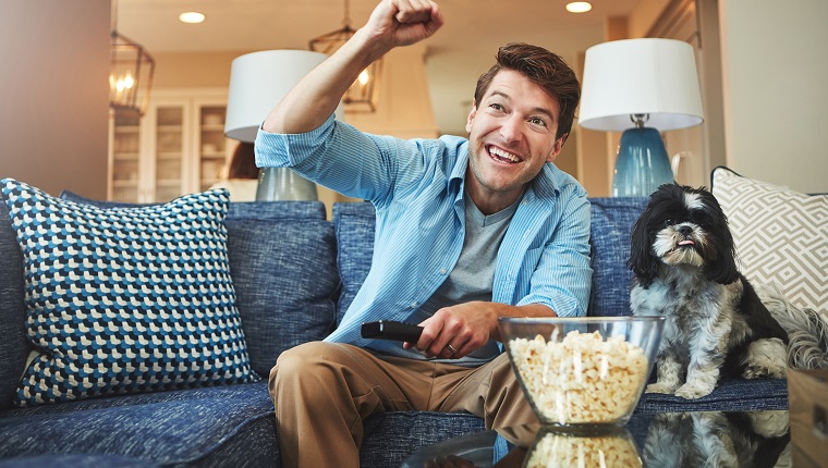 Shot of a happy man celebrating while watching a sports match on tv