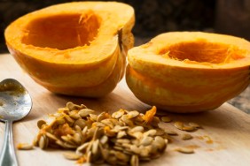 Winter squash cut in half with spoon and seeds scooped out.