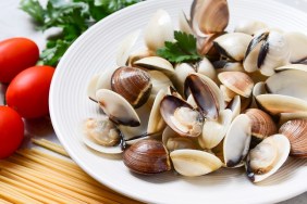 clams, spaghetti, tomatoes and parsley. recipe for traditional seafood Italian pasta Spaghetti alle Vongole. on a gray background. top view, food flat lay