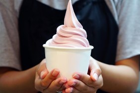 Closeup of woman 's hand holding takeaway cup with organic frozen yogurt ice cream, It's delicious and healthy enjoy eating concept.