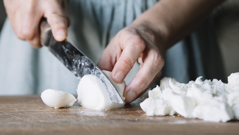 Close-up of woman cutting mozzarella