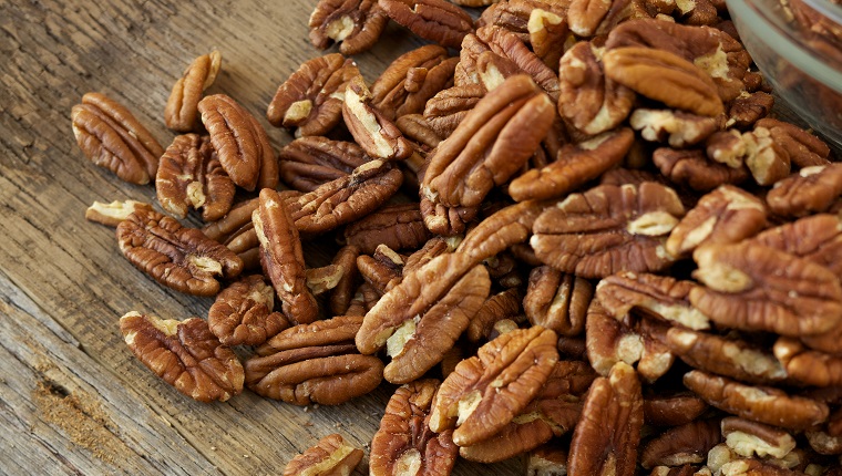 Natural light photo of pecan nuts and glass bowl on rustic wood tablePlease view more rustic food images here: