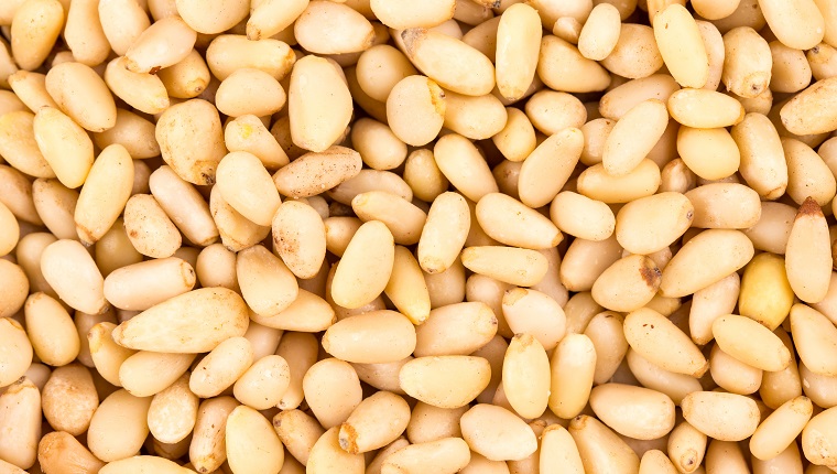 Delicious healthy peeled pine nuts. Whole background. It occupies the entire surface of the image. Close-up.