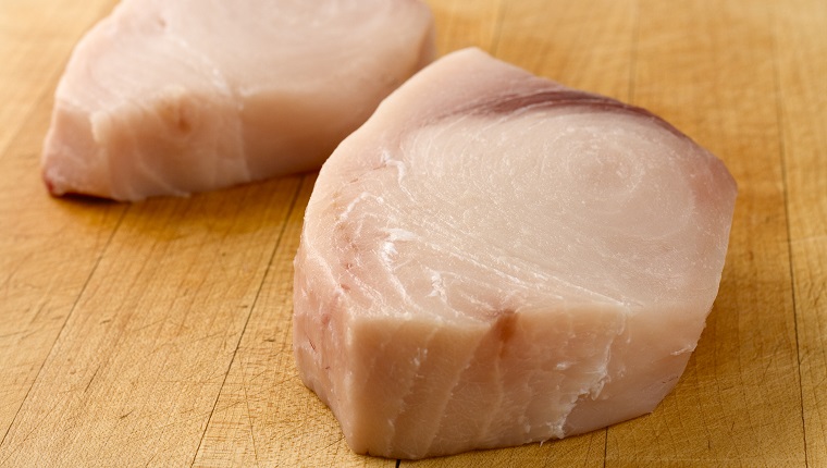 Two fresh swordfish steaks, trimmed and ready for the grill.