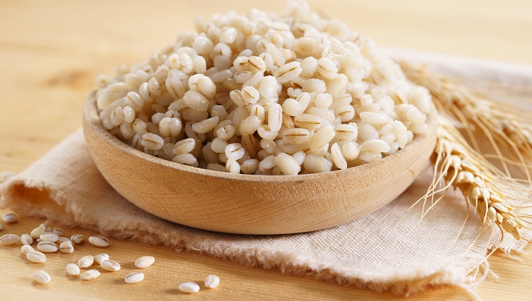 Cooked peeled barley grains in wooden plate