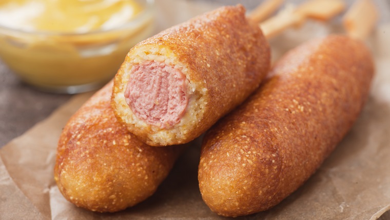 Home made corn dog fried sausage skewer with mustard