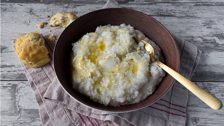 southern grits with biscuits and butter on rustic table top view