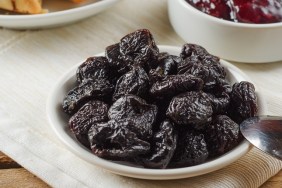 Prunes on small plate with jam from the plums on a wooden table. Dried Plums. Healthy and vegetarian food.