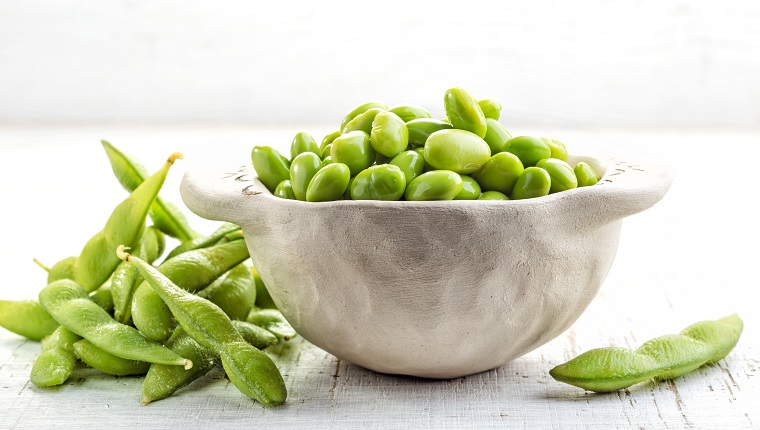 bowl of green beans on white wooden table