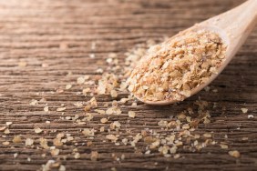 Wheat germ on wood spoon and wood background