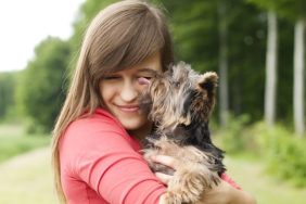 woman hugging little dog rescued car engine