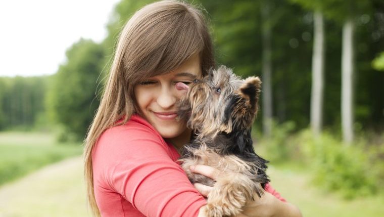 woman hugging little dog rescued car engine