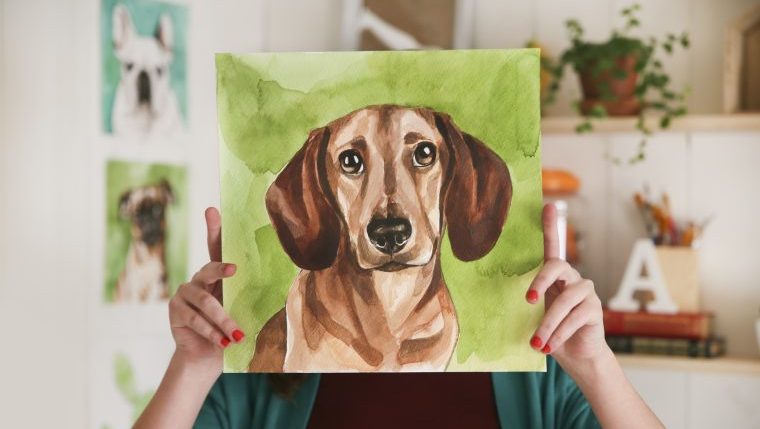 woman holding up a custom dog portrait