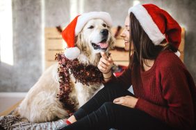 Young woman celebrating Christmas with her dog.