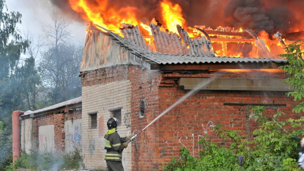 Firefighter extinguishing a building on fire, like the Ohio puppy mill building that went up in flames, killing 70 dogs