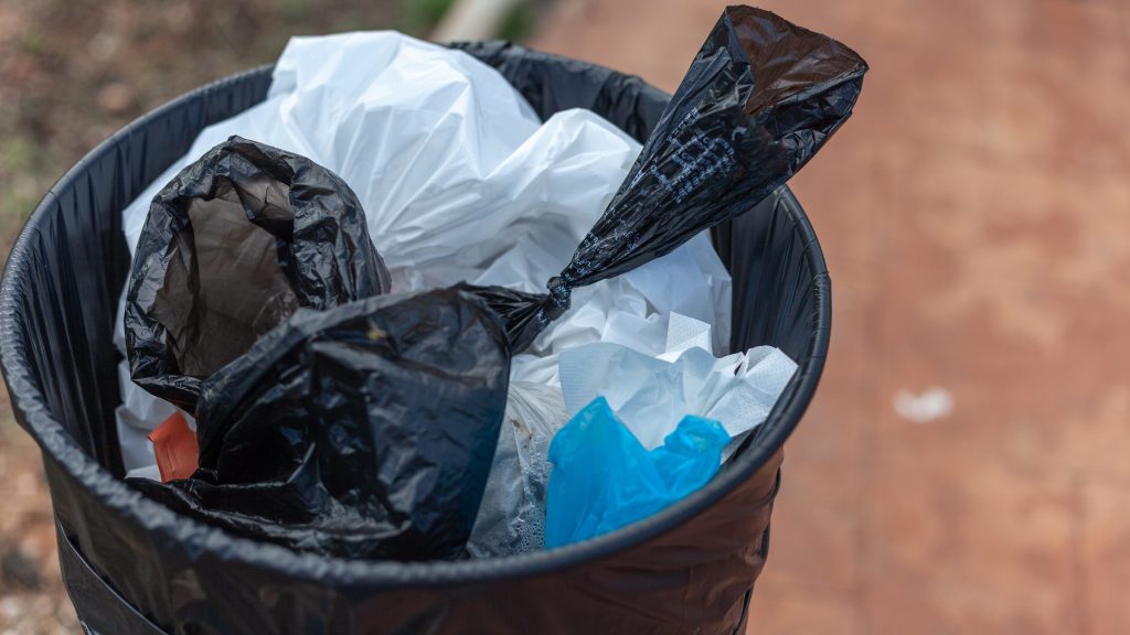 Trash can full of bags with dog excrement