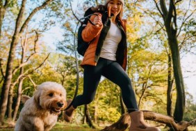 Woman going for a hike with her Goldendoodle dog.