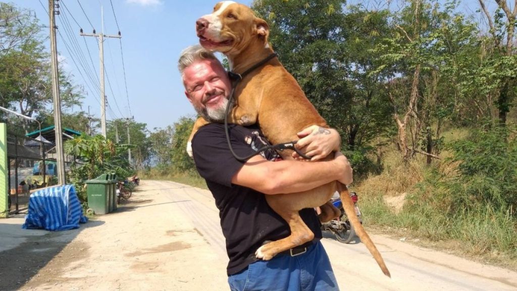 Michael J. Baines, co-founder and president of The Man That Rescues Dogs who wrote a new book to help raise funds for stray and disabled canines, with a dog.